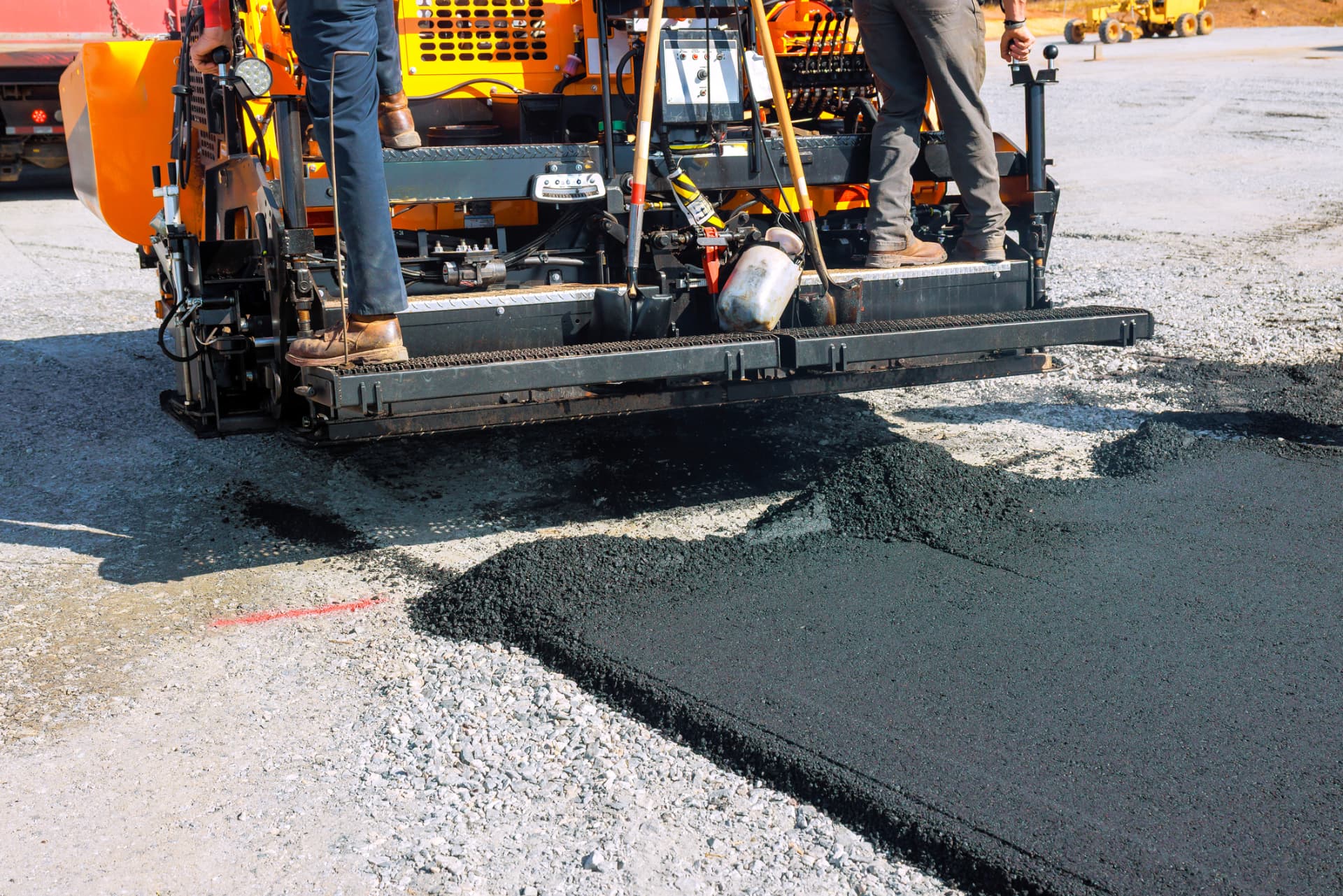 Asphalt paver laying a fresh mat over a stone base on a Toms River, NJ job site