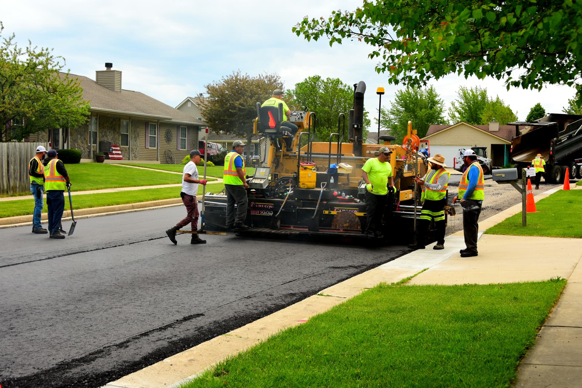 Full paving crew resurfacing a neighborhood street in Freehold, NJ