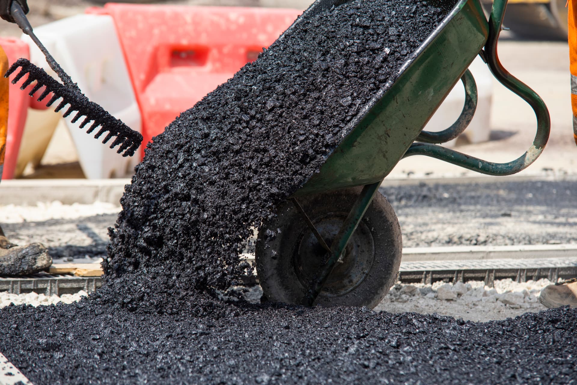 Wheelbarrow dumping hot-mix asphalt for a hand-placed driveway section
