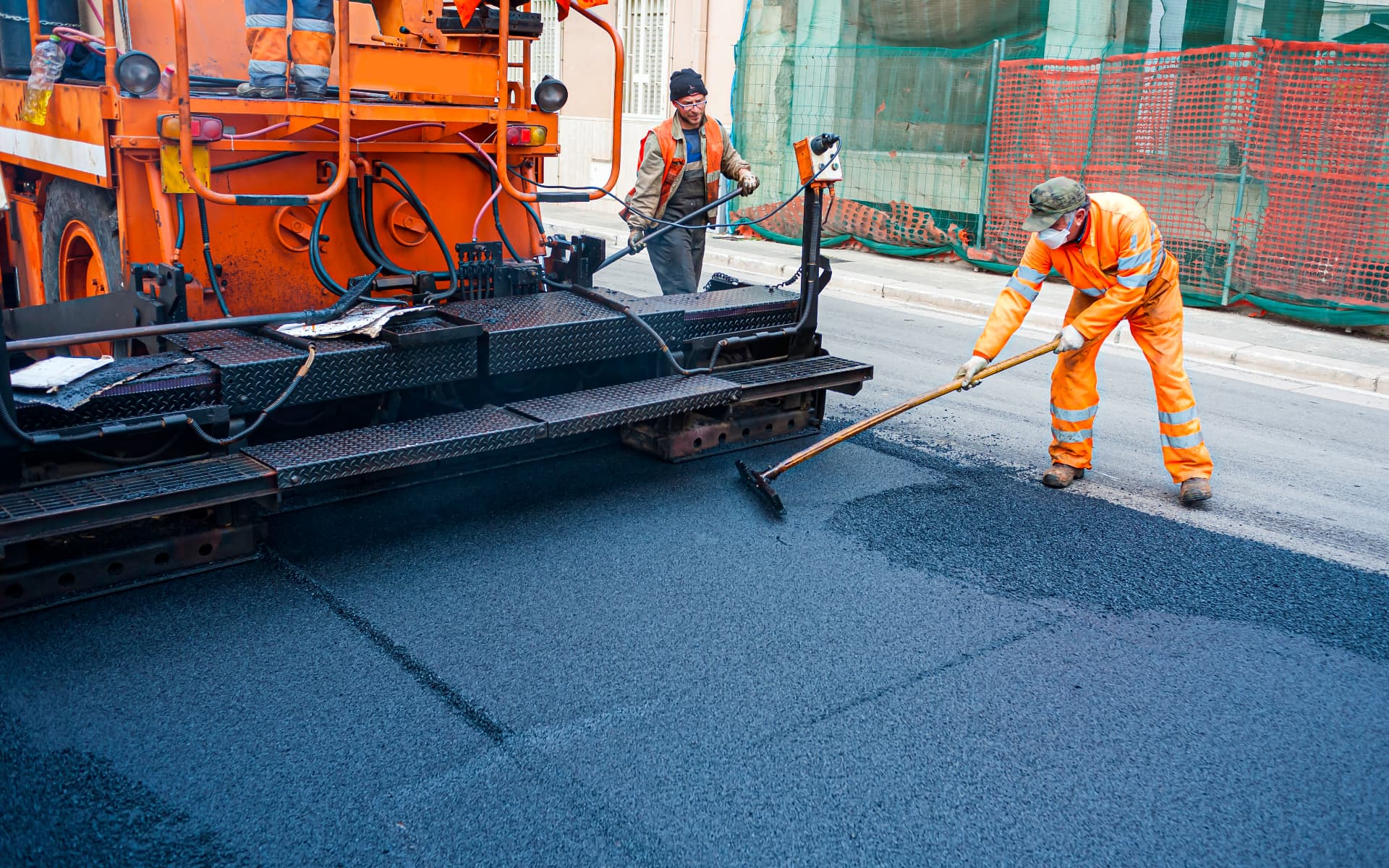 Paving crew laying hot-mix asphalt on a street resurfacing project in Edison, NJ
