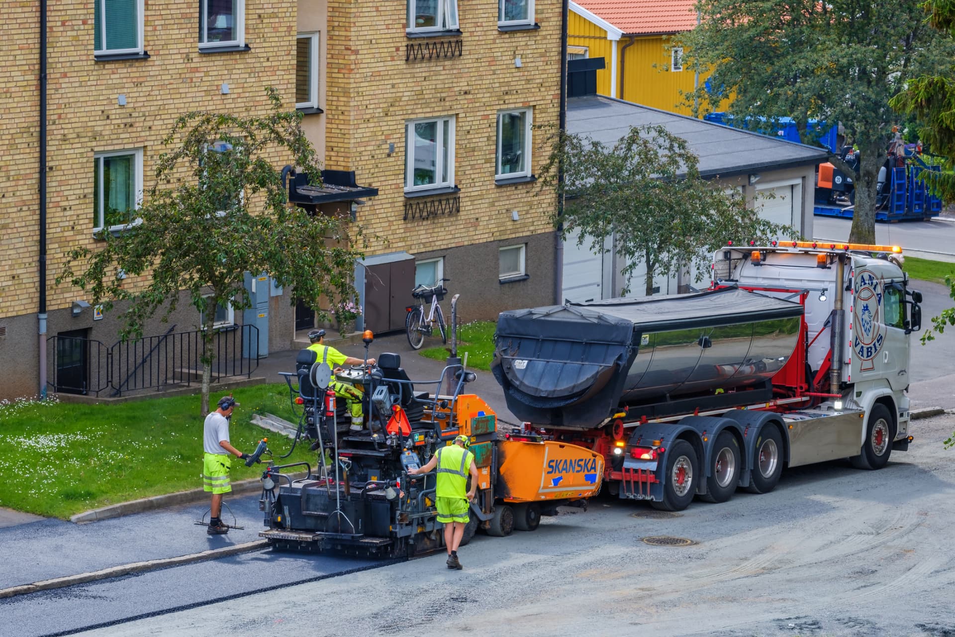 Paving crew and material truck resurfacing a residential street in Edison, NJ
