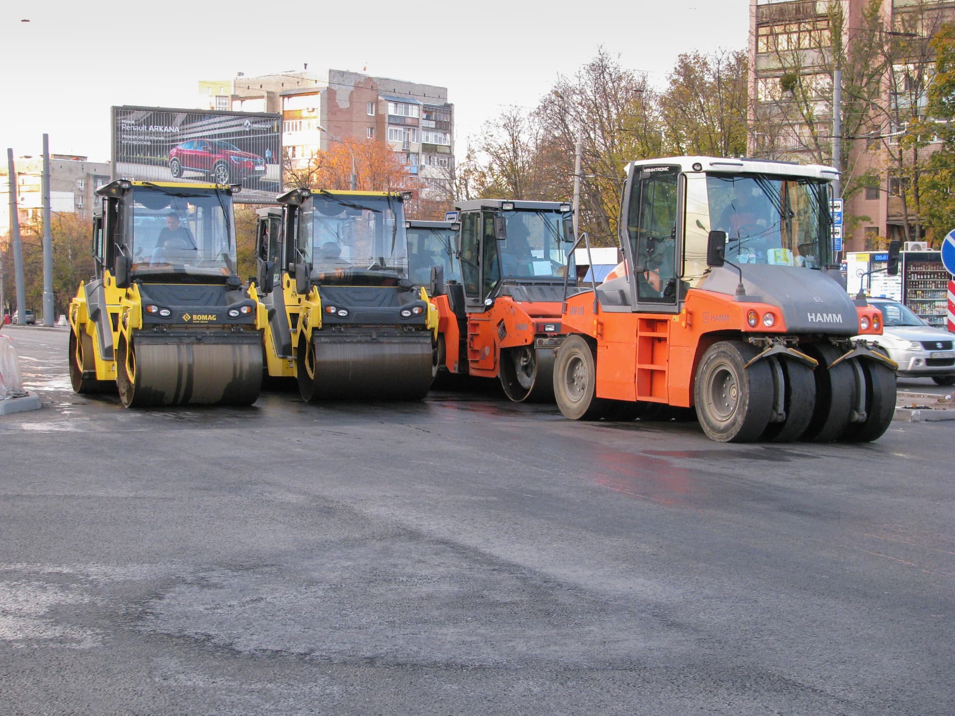 Line of compaction rollers staged on a large commercial paving job